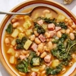One bowl of white bean and kale soup up close.