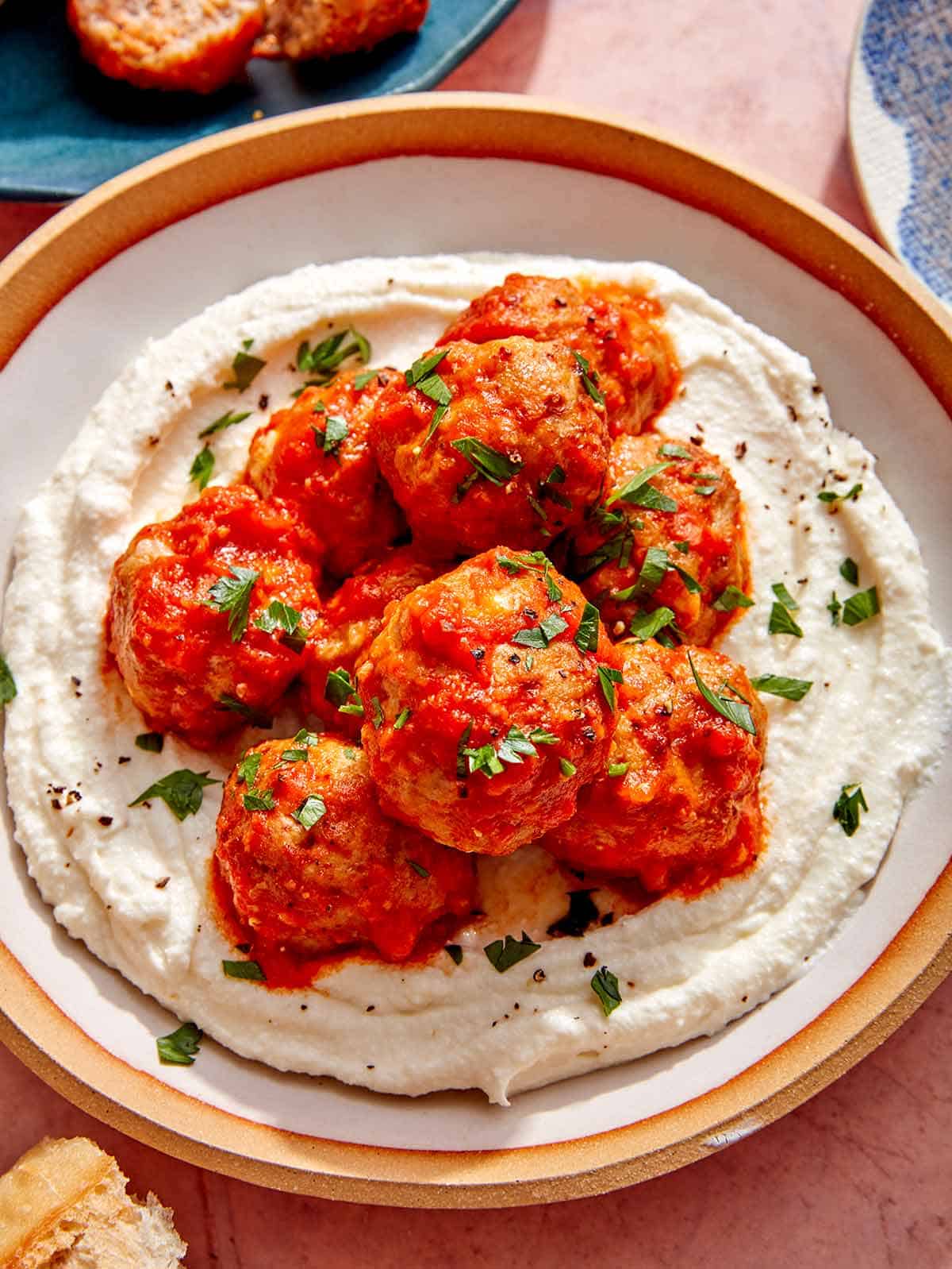 Air fryer meatballs on a plate with ricotta. 