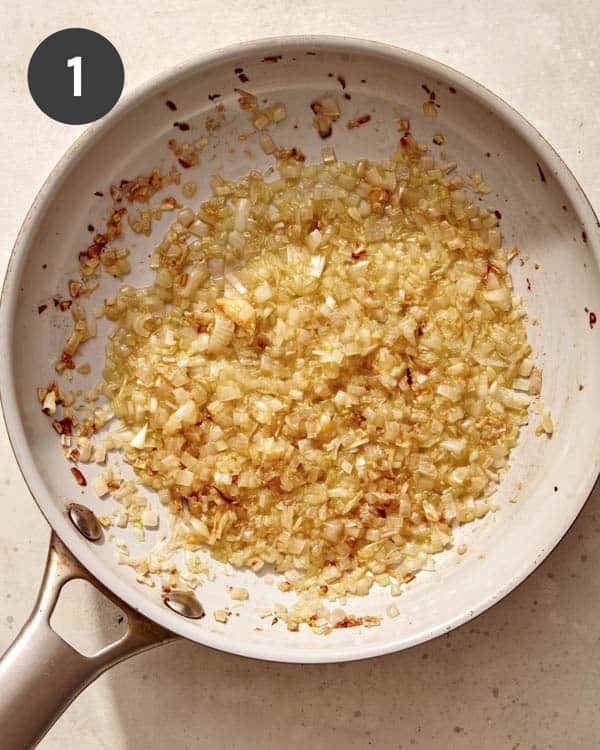 Shallots and garlic cooking in a pan.