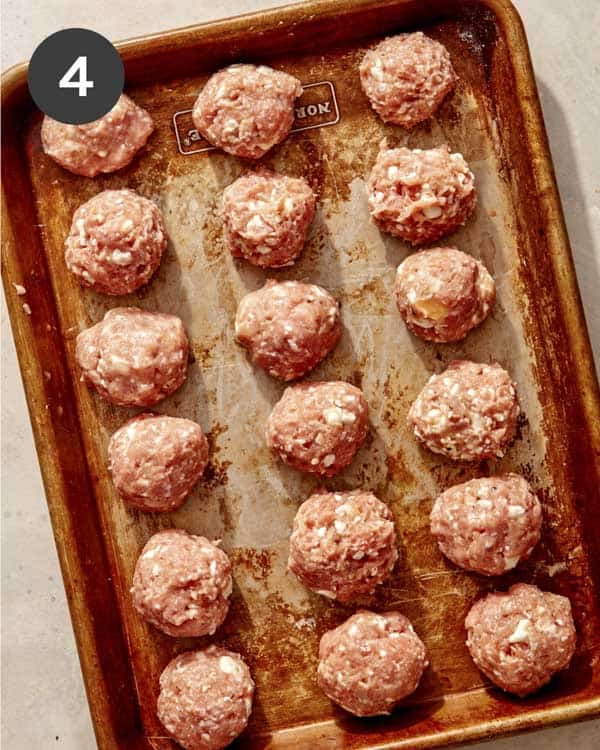 Turkey meatballs rolled on a baking sheet. 