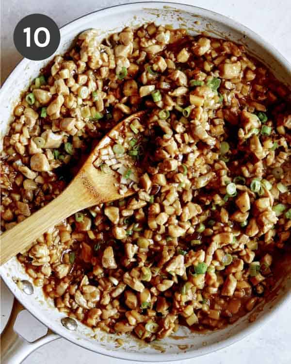 Chicken lettuce wraps in a skillet with green onions.