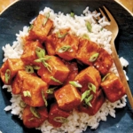 Crispy air fryer tofu with a sweet chili sauce on a bed of rice.