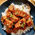 Crispy air fryer tofu with a sweet chili sauce on a bed of rice.