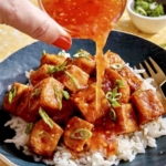 Crispy air fryer tofu with sweet chili sauce being poured all over.