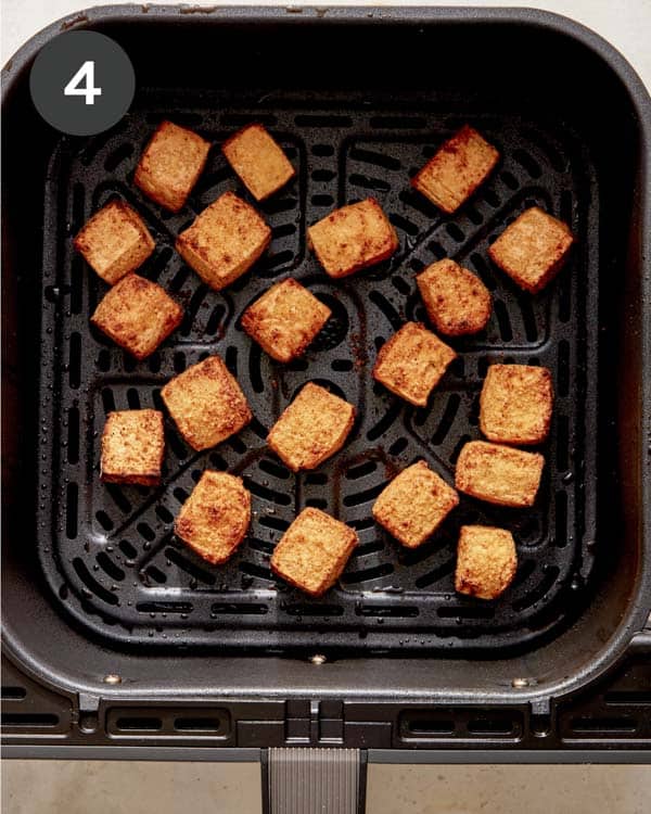 Tofu cooked in an air fryer basket. 