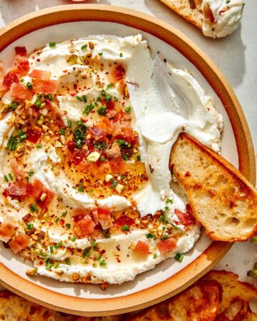 Whipped goat cheese with a crostini dipped in it.