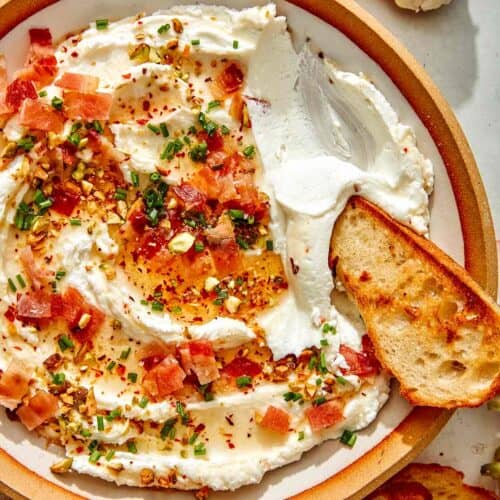 Whipped goat cheese with a crostini dipped in it.