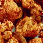 Air fryer cauliflower with a spoon on a plate.