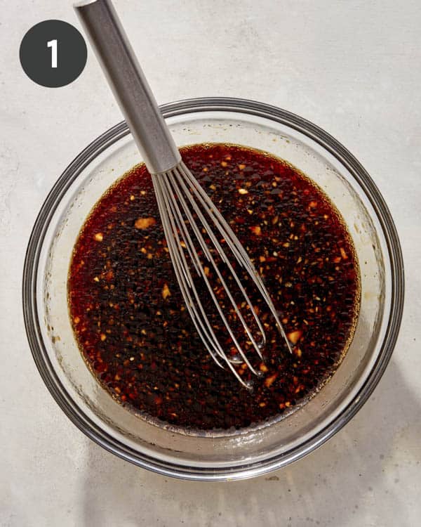 Sauce in a bowl being whisked together.