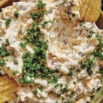 Baked potato dip recipe in a bowl with chips.