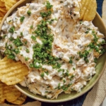 Baked potato dip in a bowl served with chips.