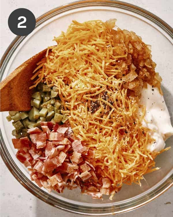 Ingredients added to a bowl to be mixed together for baked potato dip. 