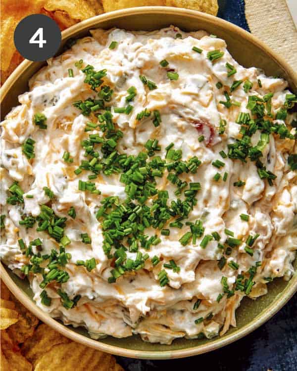 Baked potato dip in a bowl with chives sprinkled on top. 