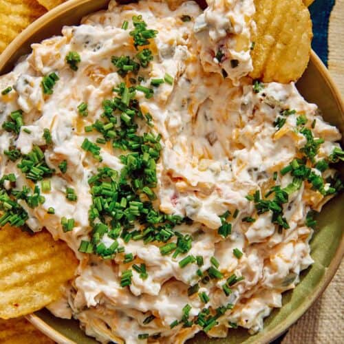 Baked potato dip recipe with potato chips dipped in it.
