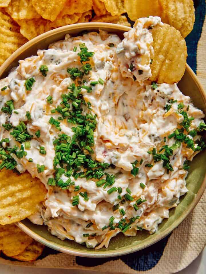 Baked potato dip recipe with potato chips dipped in it.