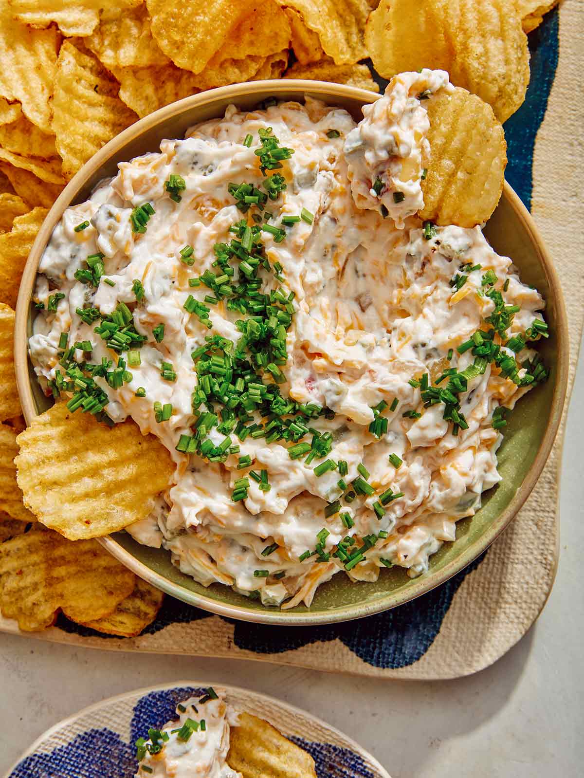 Baked potato dip in a bowl served with chips. 