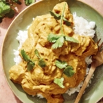 Chicken korma on a plate with rice and a fork.