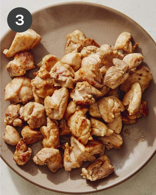 Chicken thighs cooked and resting on a plate.