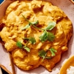 Chicken korma in a bowl with cilantro on top.