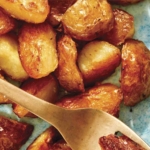Crispy roasted potatoes on a platter with a fork.