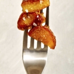 Crispy roasted potatoes speared onto a fork.
