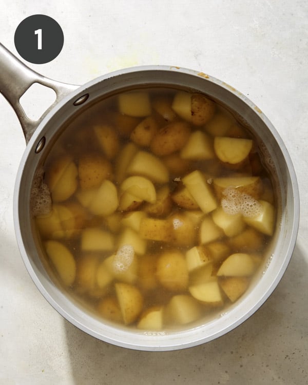 Potatoes boiling in a pot of water. 