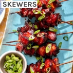 Air fryer chicken skewers with green onions on top.