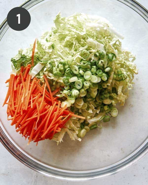 Adding veg to a bowl to make okonomiyaki recipe.