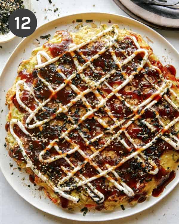 Okonomiyaki on a plate with fork next to it.