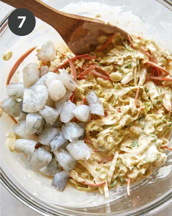 Adding shrimp to okonomiyaki batter.