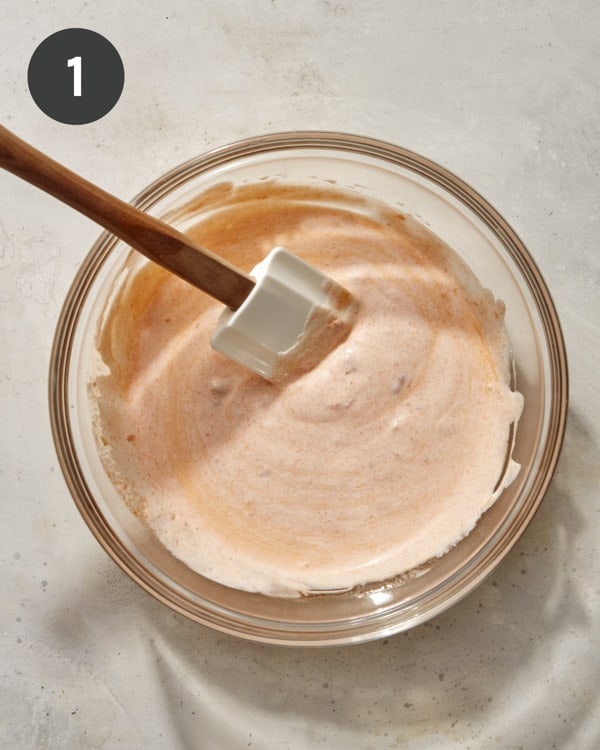 Spicy dill pickle dip on a bowl being mixed together.
