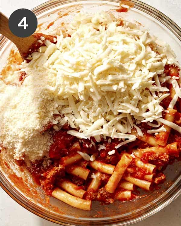 Cheese being mixed with pasta and meat for baked ziti. 