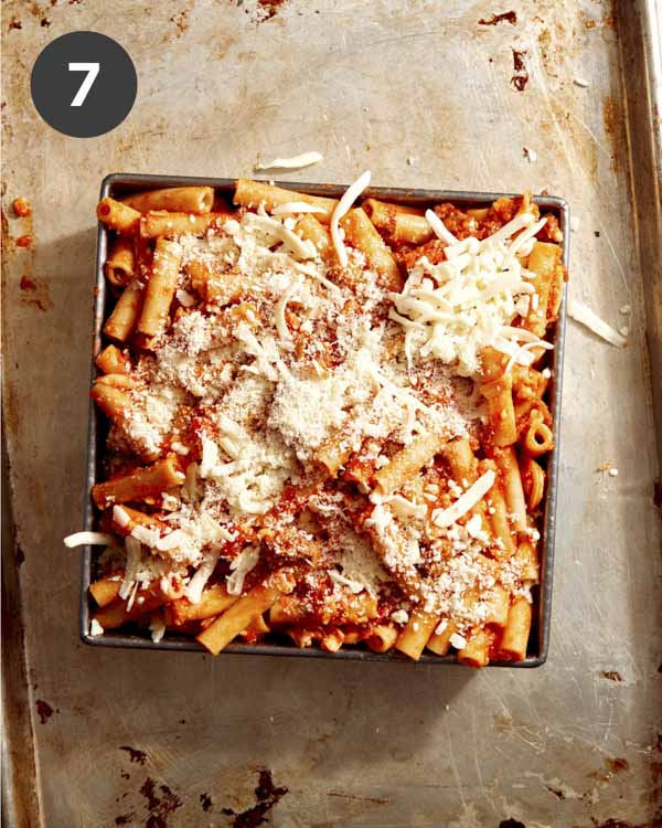 Baked ziti in a baking dish topped with some cheese. 
