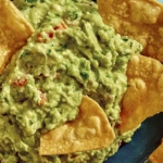 Guacamole up close in a bowl with chips in it.