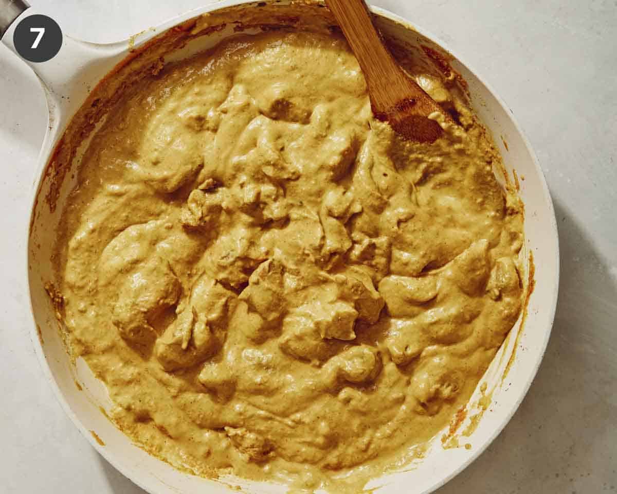 Chicken korma cooking in a skillet. 