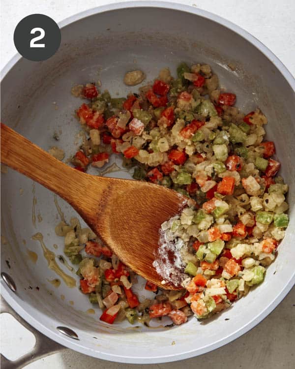 Vegetables for chicken pot pie cooking in a pot with flour. 