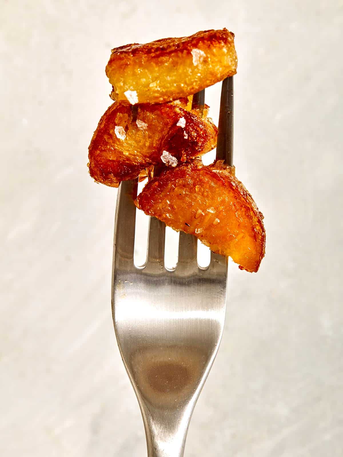 Crispy roasted potatoes speared onto a fork. 