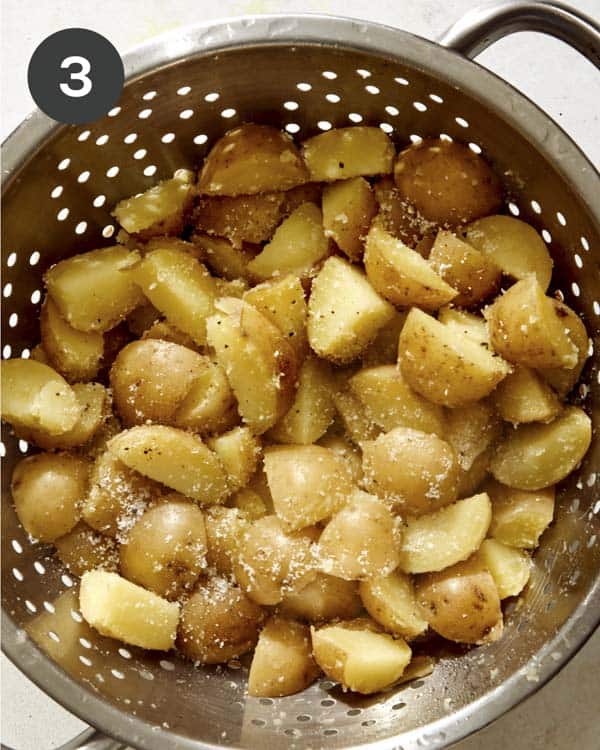 Drained potatoes in a colander with salt. 