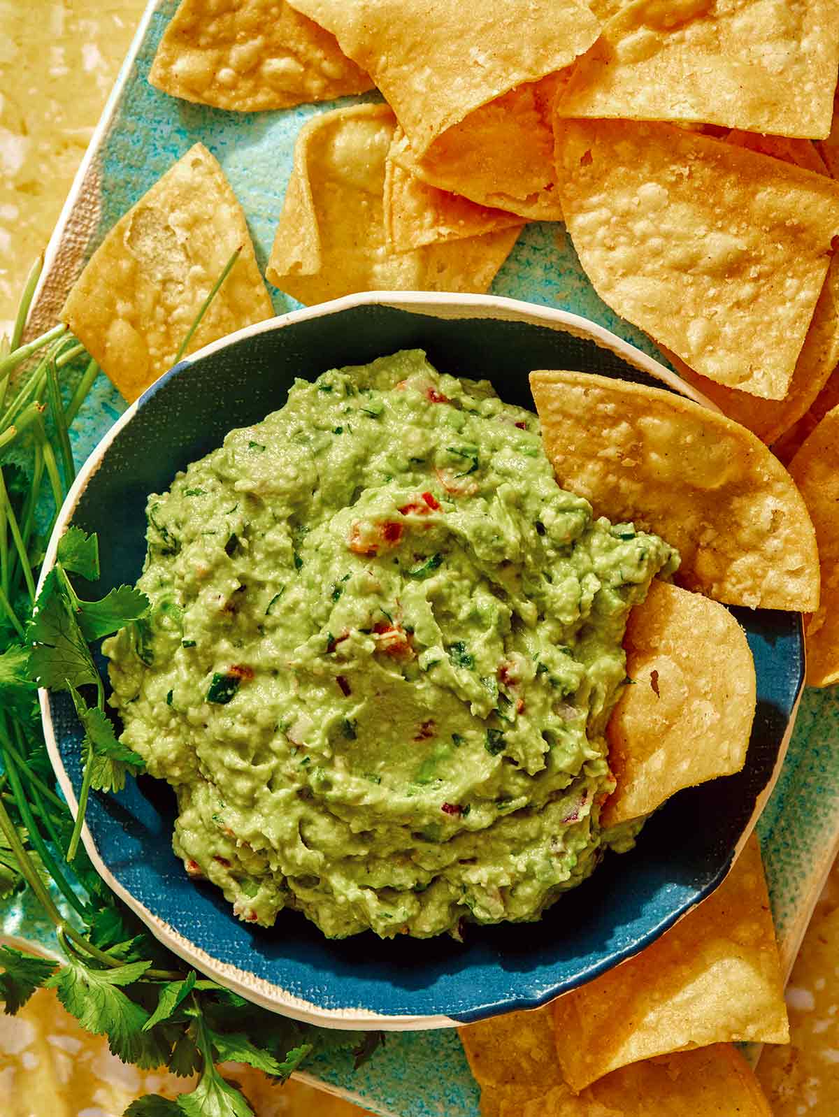 Guacamole recipe in a bowl with chips on the side. 