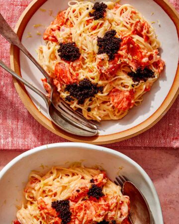 Smoked salmon pasta in two bowls with forks on the side.