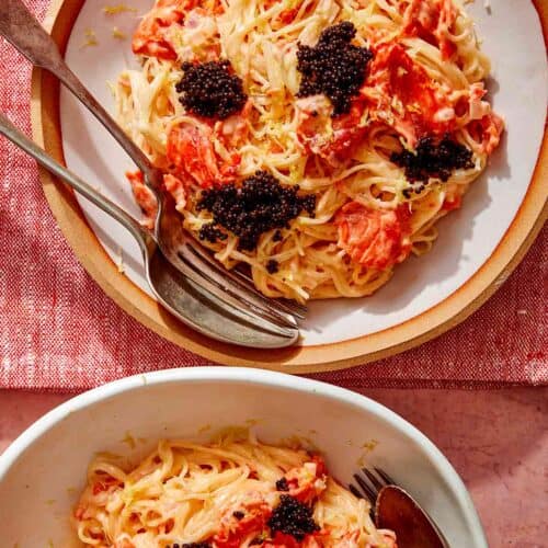 Smoked salmon pasta in two bowls with forks on the side.