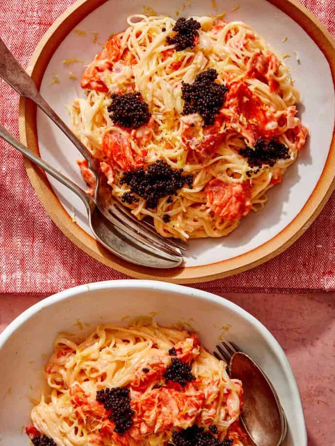 Smoked salmon pasta in two bowls with forks on the side.