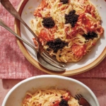 Smoked salmon pasta in two bowls with forks on the side.