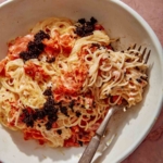 Close up on a bowl of smoked salmon pasta with a fork.