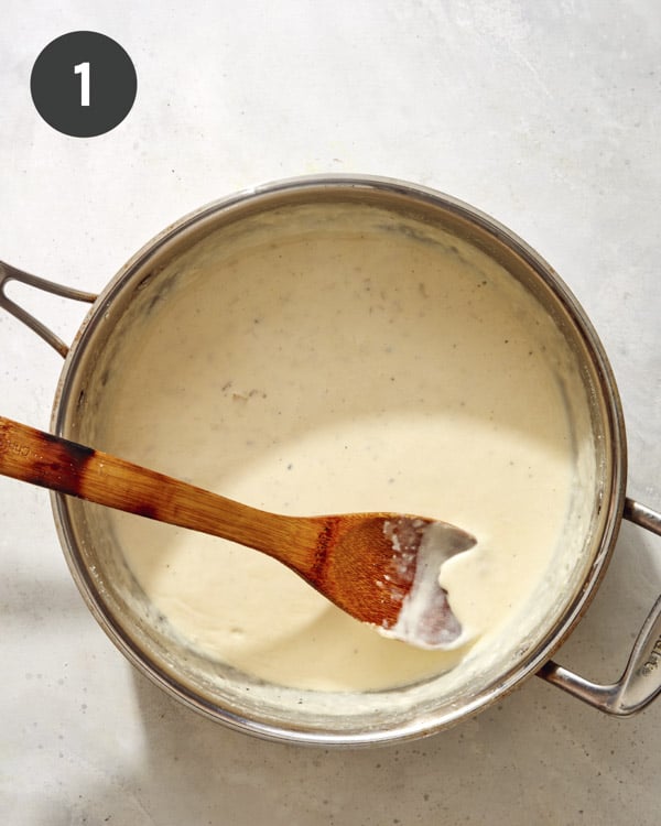 Creamy sauce being made in a skillet to make smoked salmon pasta.