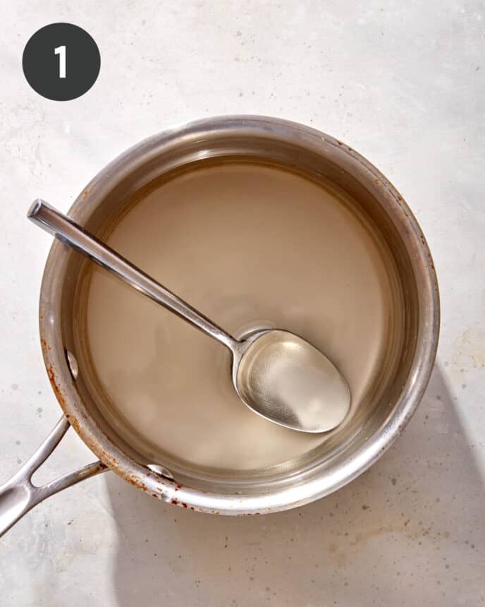 Sugar and water in a pot to make sweet chili sauce. 