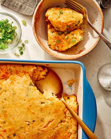 Jalapeno cheddar spoon bread in a baking dish with some served into a bowl.