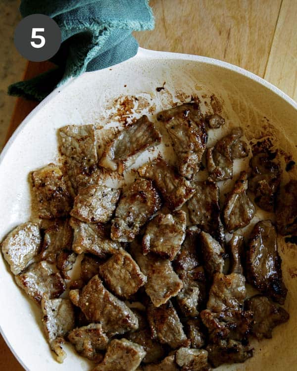 Cooking strip steak in a skillet to make Mongolian Beef.