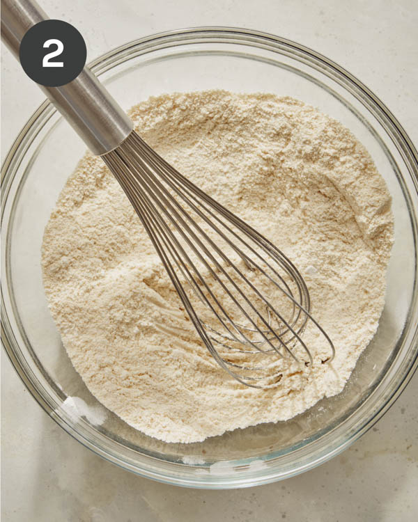 Spoon bread dry ingredients whisked together in a glass bowl. 