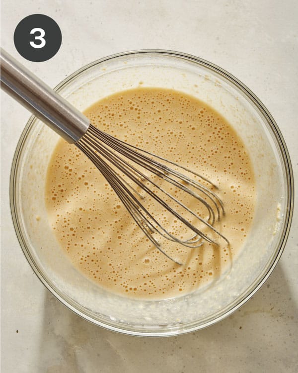 Spoon bread wet ingredients being mixed in a bowl. 